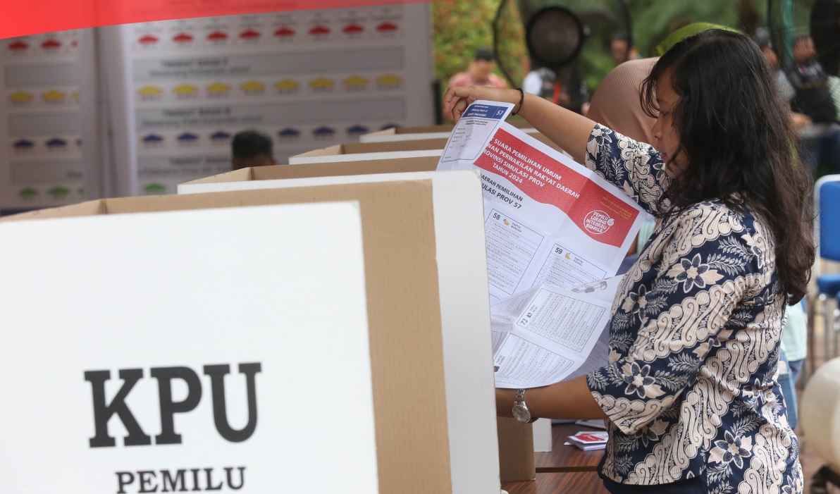 Seorang Wanita memberikan suaranya di bilik suara
