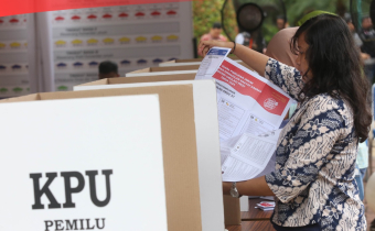 Seorang Wanita memberikan suaranya di bilik suara